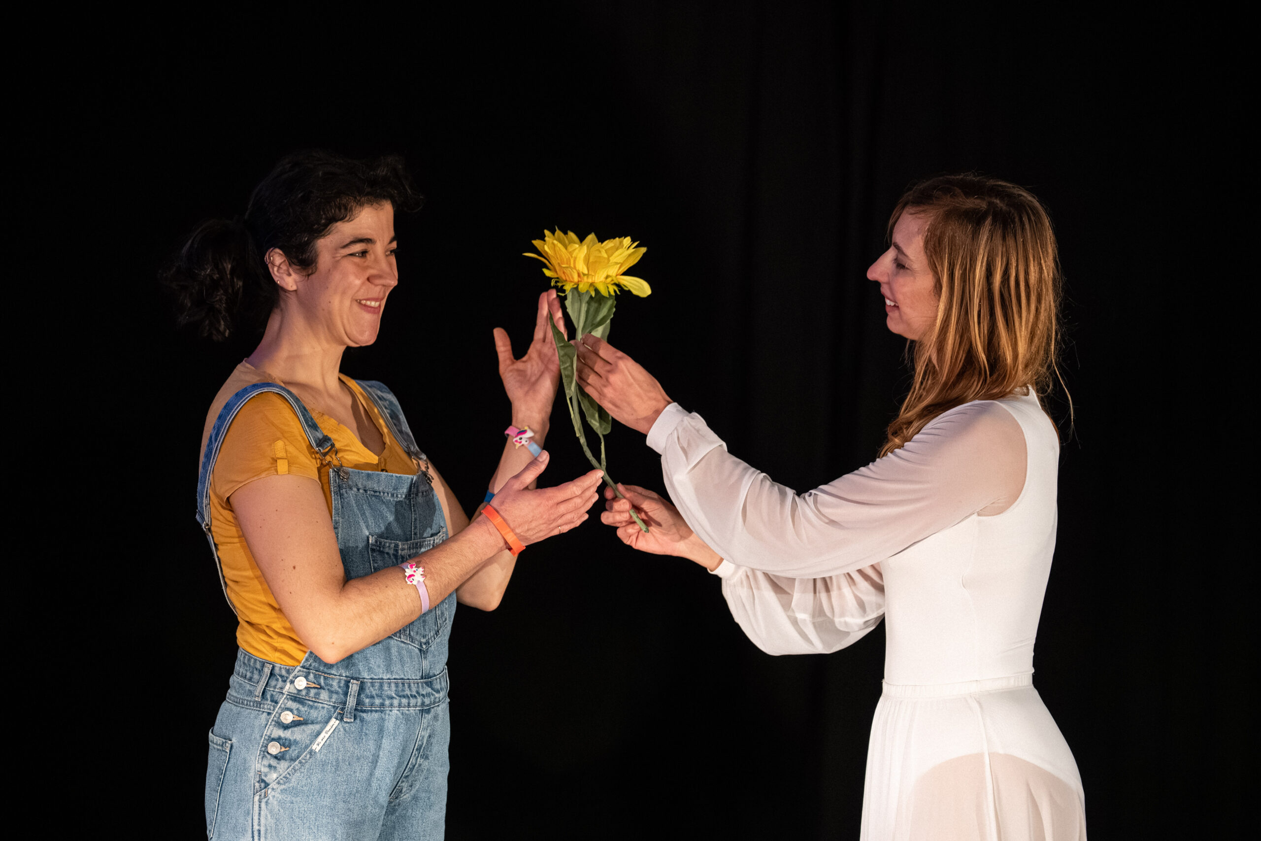 Les deux interprètes se tendent une fleur jaune dans Mon trésor, Cie L’Autre et Moi