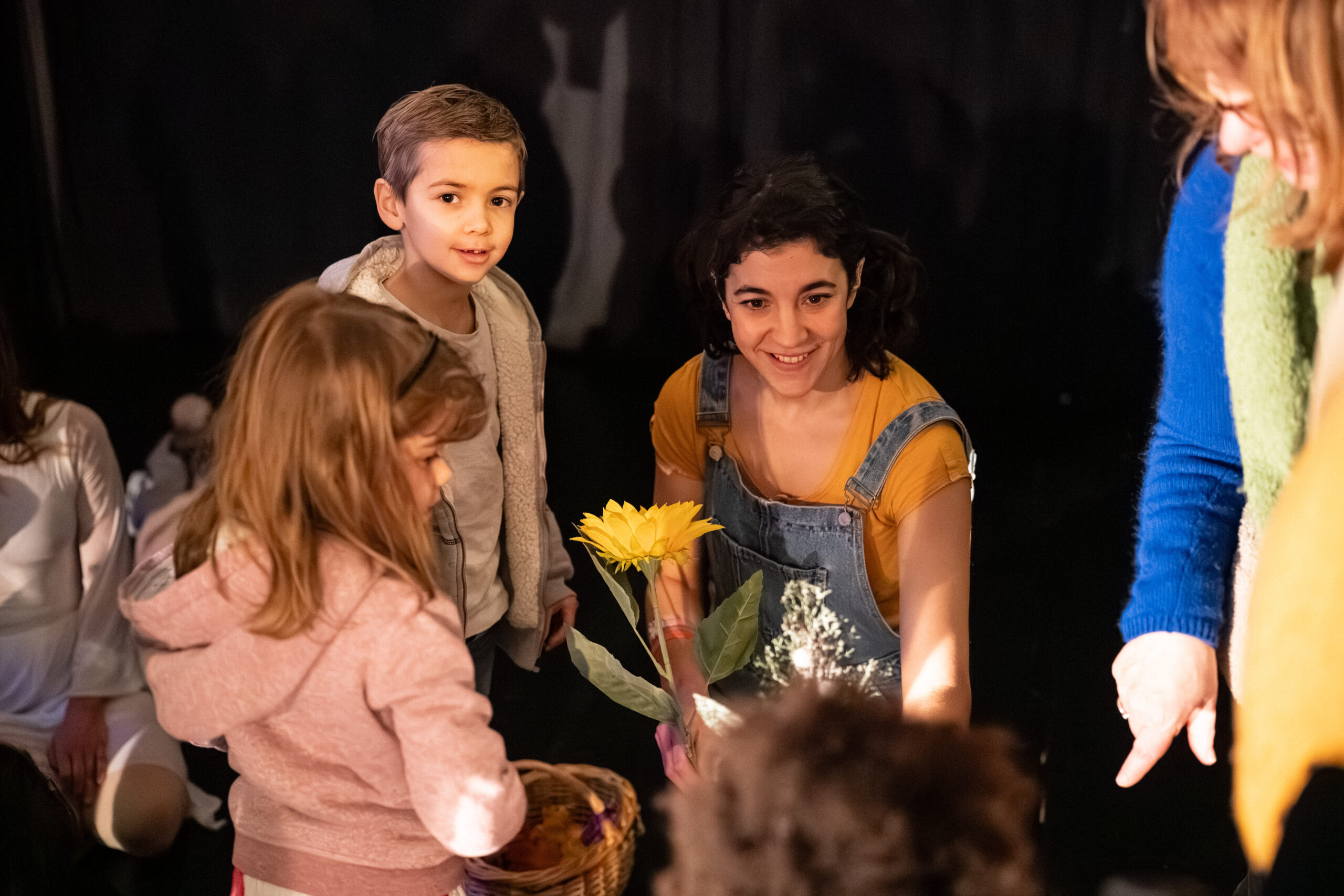 Des enfants découvrent les objets du spectacle Mon trésor avec une comédienne
